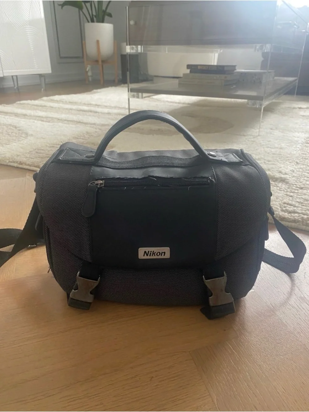 Nikon 3100 black DSLR with zoom lens and attached USB cable
